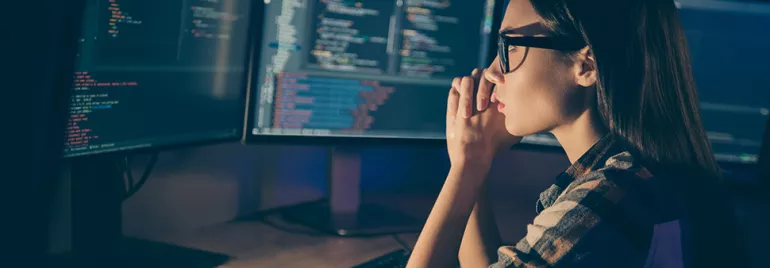 Une personne travaille sur des codes informatiques à l'écran.