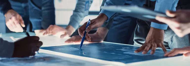 Personnes discutant autour d'une table avec des plans.