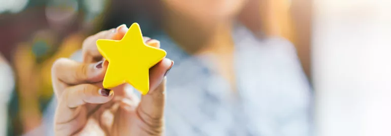 Main tenant une étoile jaune en gros plan.