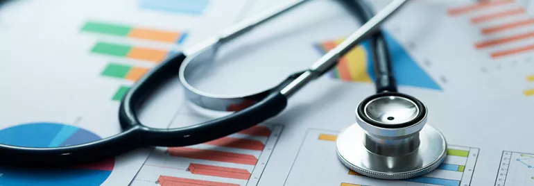 Stéthoscope posé sur des graphiques colorés représentant des données médicales.