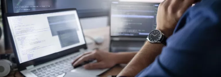 Personne utilisant un ordinateur portable avec du code à l'écran.