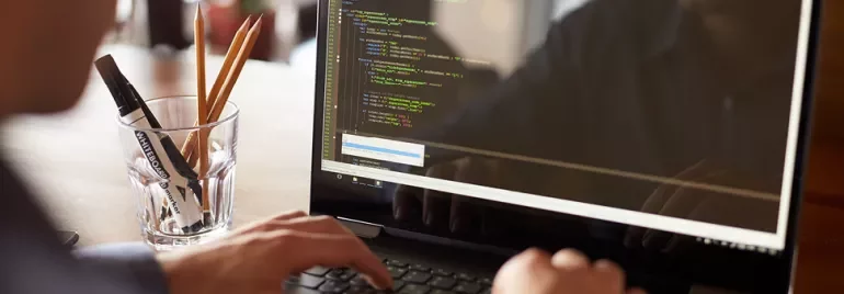 Personne tapant du code sur un ordinateur portable.