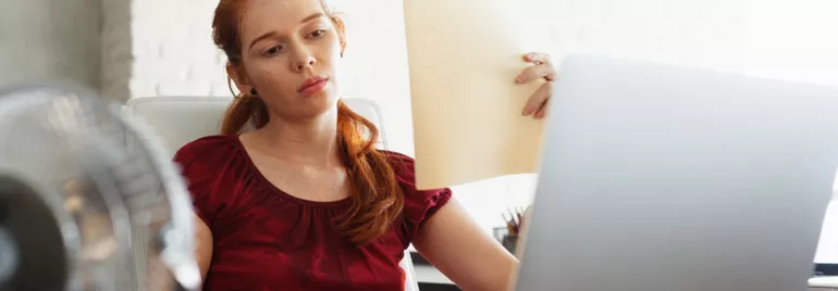 Personne regardant un document devant un ordinateur.
