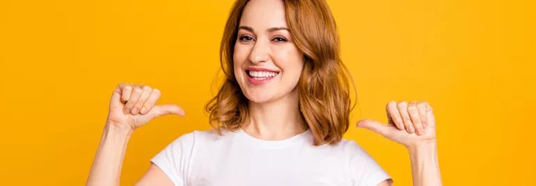 Personne souriante en t-shirt blanc sur fond jaune.