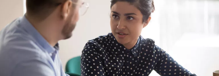 Deux personnes discutant dans un bureau.