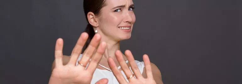 Personne levant les mains avec une expression incertaine.
