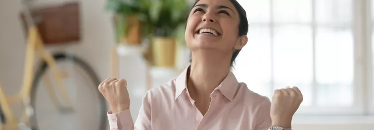 Personne souriante, les poings levés avec joie.