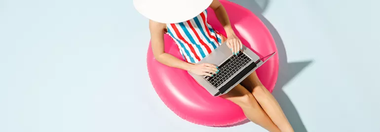 Personne utilisant un ordinateur portable sur une bouée rose.