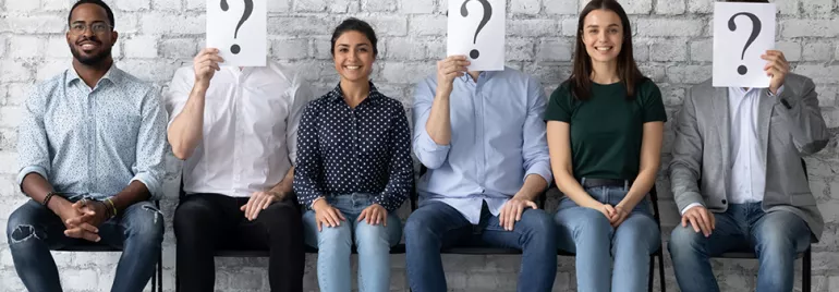 Groupe de personnes assises, certains cachant leur visage avec un point d'interrogation.