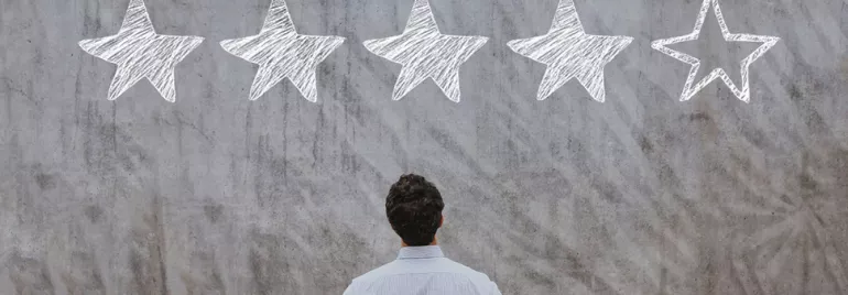 Personne observant un mur avec quatre étoiles remplies et une étoile vide.