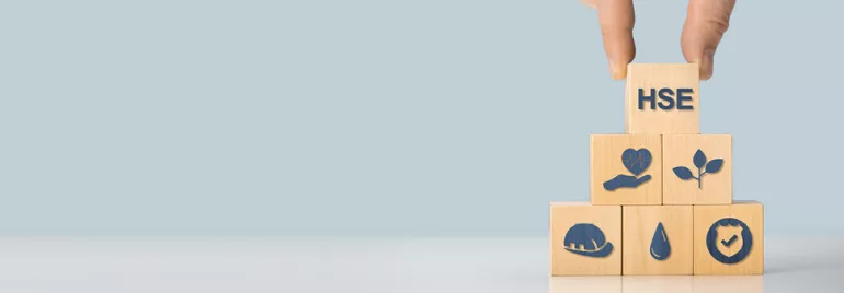 Main empilant des cubes en bois avec des icônes de santé et sécurité.