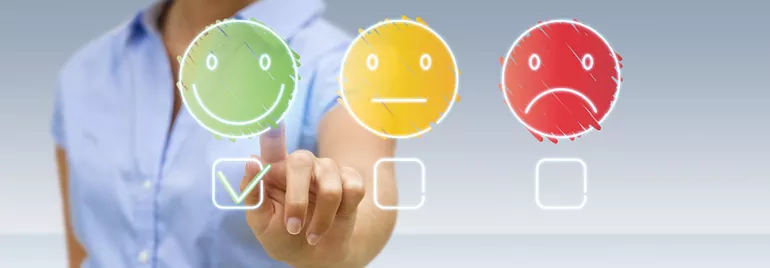 Une personne choisit un visage heureux parmi trois options d'humeur