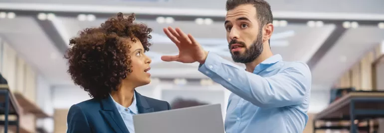 Deux personnes en discussion dans un bureau moderne.