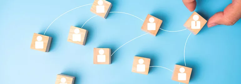 Blocs de bois avec icônes de personnes connectées par des lignes blanches sur fond bleu.