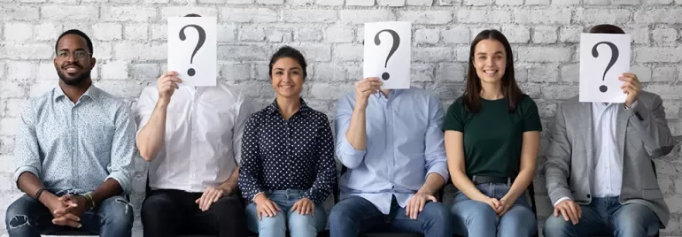 Groupe de personnes assises, trois cachent leurs visages avec un point d'interrogation.