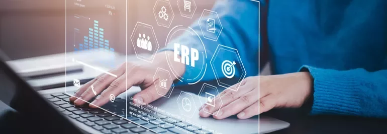 Personne utilisant un ordinateur avec des graphiques ERP à l'écran.