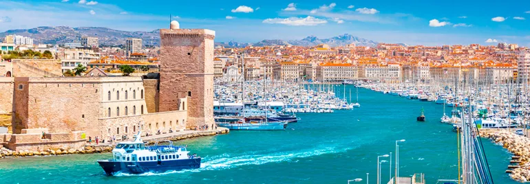 Vue du Vieux-Port de Marseille avec des bateaux et des bâtiments historiques.