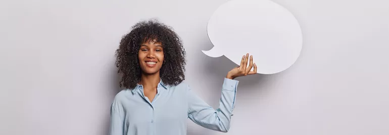 Personne souriante tenant une bulle de discours blanche.