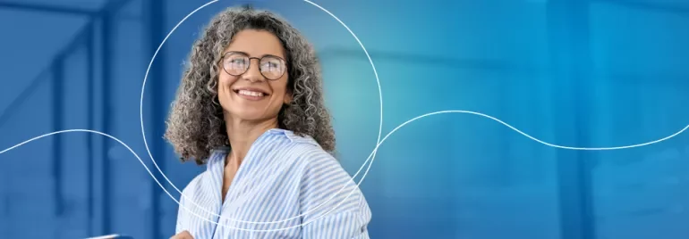 Personne souriante avec des lunettes à l'intérieur.