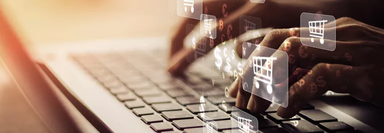 Mains tapant sur un clavier avec des icônes de panier d'achat.