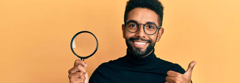 Personne souriante avec loupe et pouce levé.