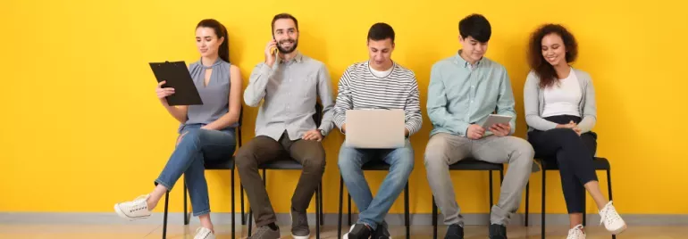 Groupe de personnes assises contre un mur jaune.