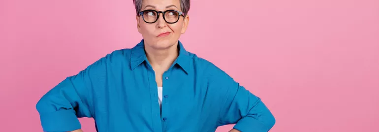 Personne avec des lunettes sur fond rose.