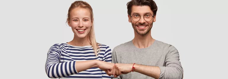 Deux personnes souriantes se tapent le poing.