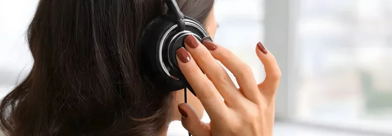 Femme de dos passant un appel téléphonique sur un casque audio