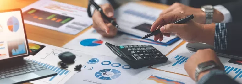 Analyste financier ou cadre finance devant des graphiques financiers sur écran.
