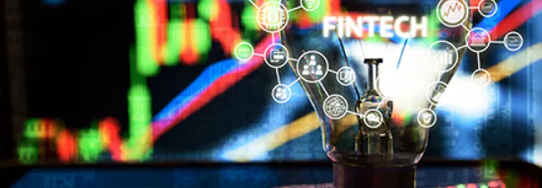Ampoule avec icônes Fintech, graphiques en arrière-plan.