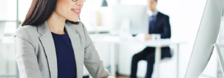 Personne travaillant à un ordinateur dans un bureau moderne.