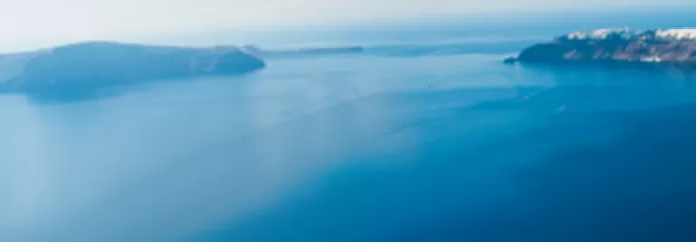 Vue panoramique de la mer avec ciel clair et îles à l'horizon.