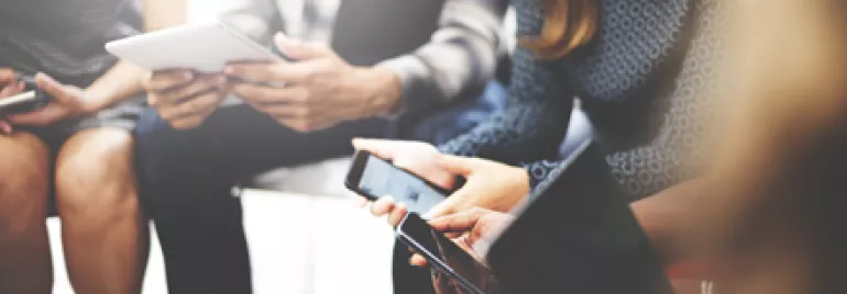 Groupe de personnes utilisant des appareils numériques.