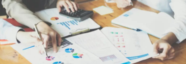 Réunion de travail avec documents et calculatrice.