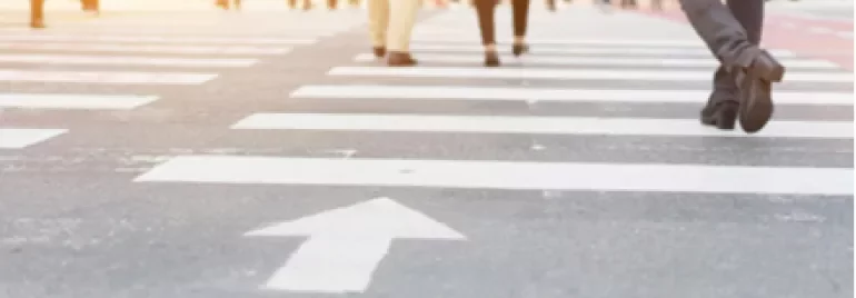 Des personnes traversant un passage piétons en ville.
