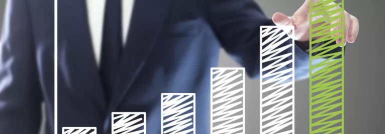 Personne en costume devant un graphique à barres en croissance.