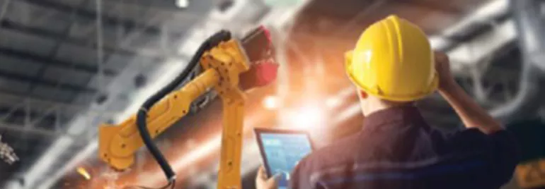 Travailleur vérifiant une machine automatisée dans une usine.