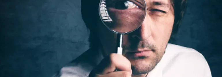 Personne regardant à travers une loupe.