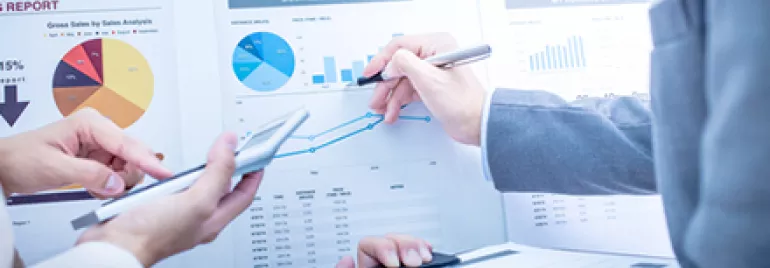 Discussion autour de graphiques financiers dans un bureau.
