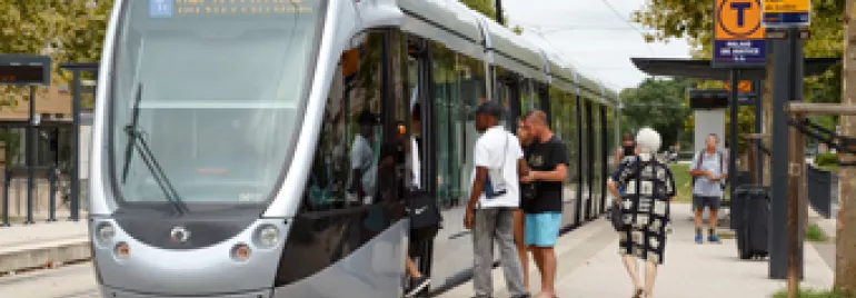Personnes montant dans un tramway à l'arrêt.
