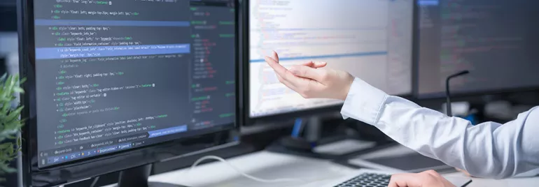 Personnes travaillant sur des codes sur des ordinateurs à plusieurs écrans.