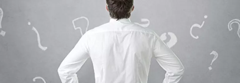 Personne en chemise blanche de dos, entourée de points d'interrogation.