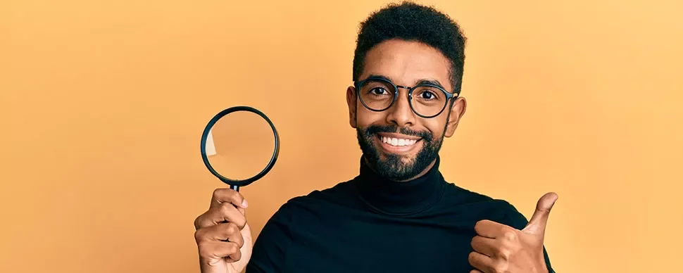 Personne souriante avec loupe et pouce levé.