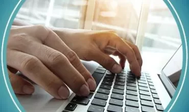 Mains tapant sur un clavier d'ordinateur portable.