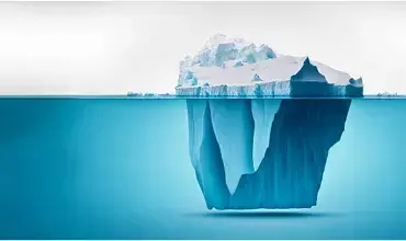 Un iceberg flottant dans la mer, avec une grande partie submergée.