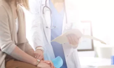 Un médecin discute avec un patient en consultation.