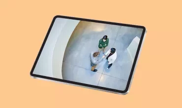 Tablette représentant trois personnes vues d'en haut, au bureau, en train de discuter de travail.