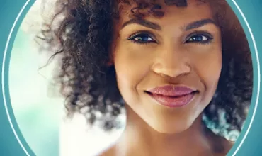 Portrait d'une personne souriante avec des cheveux bouclés.
