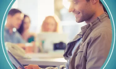 Personne souriante utilisant une tablette au bureau.